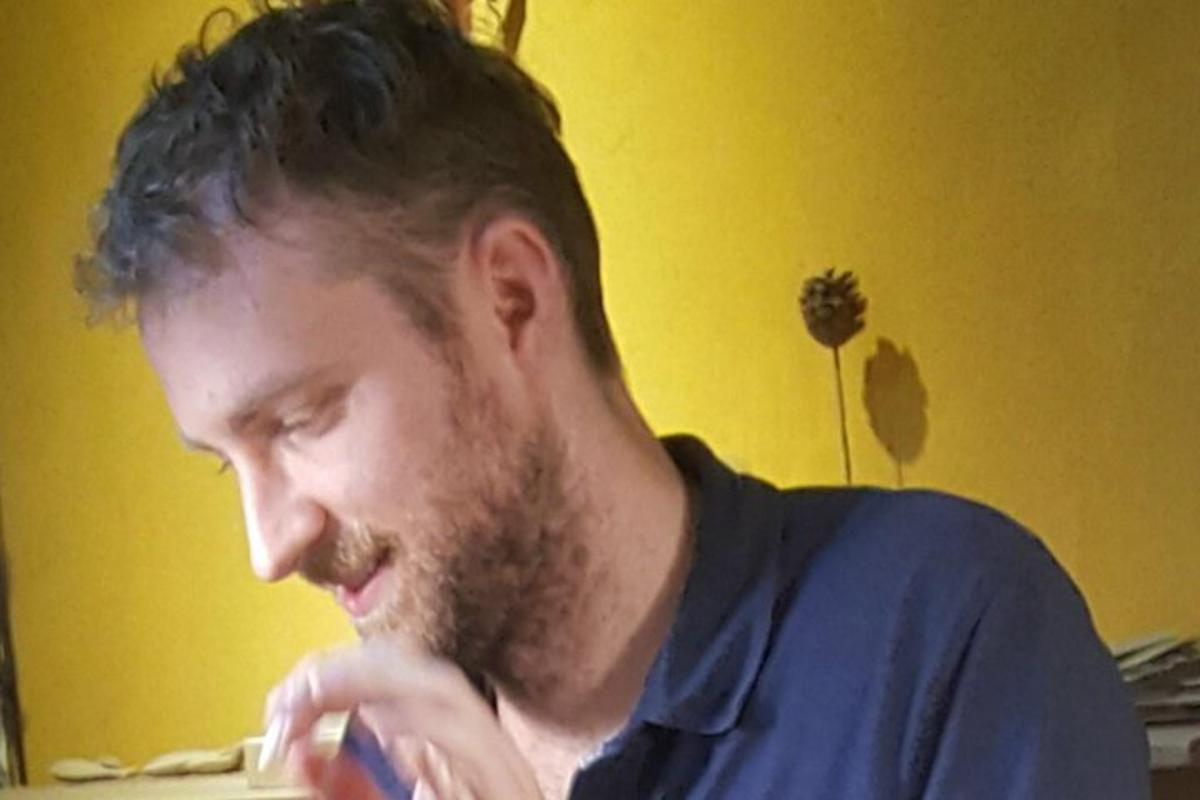 un uomo con la barba che tiene uno spazzolino da denti in bocca