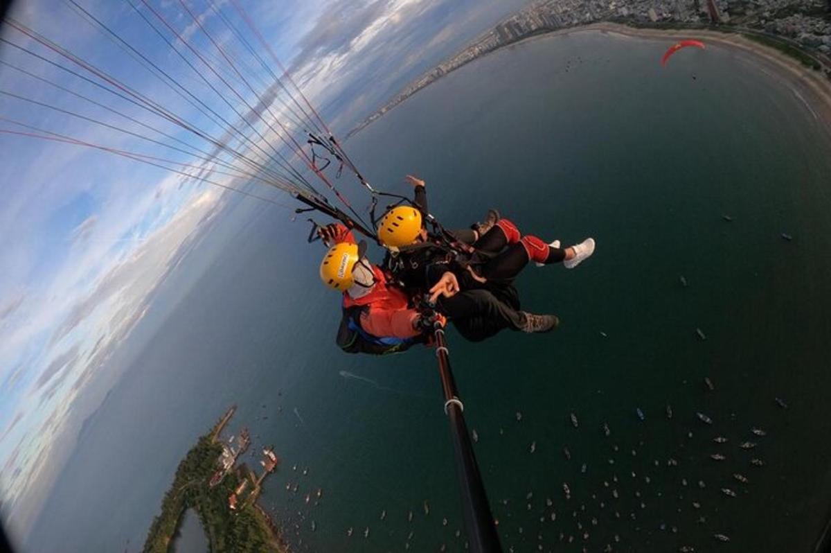 een groep mensen aan een parachute boven het water