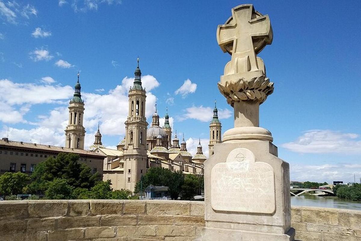 una croce in cima a un monumento di fronte a un edificio
