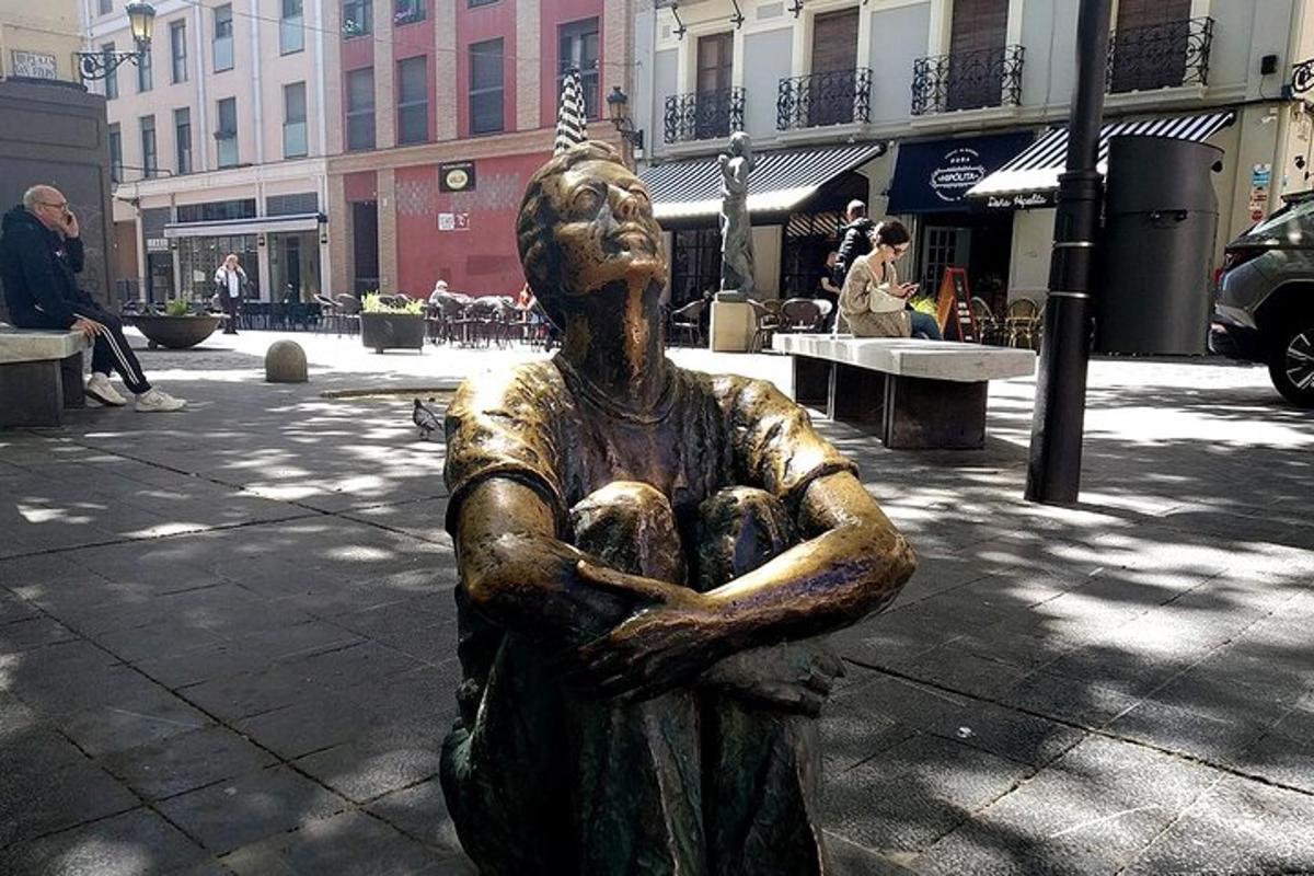 una statua di una donna seduta su una strada