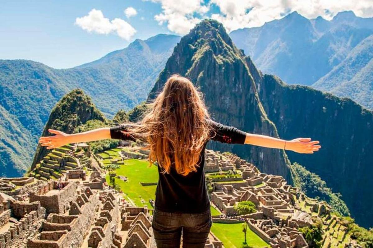 naine seisab Machu Picchu varemete tipus
