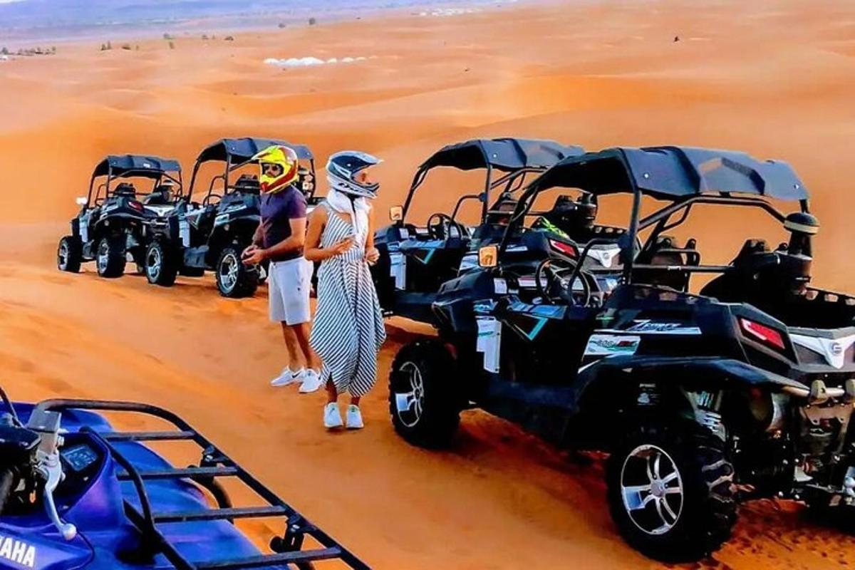 một nhóm người đang đứng trong sa mạc với xe địa hình