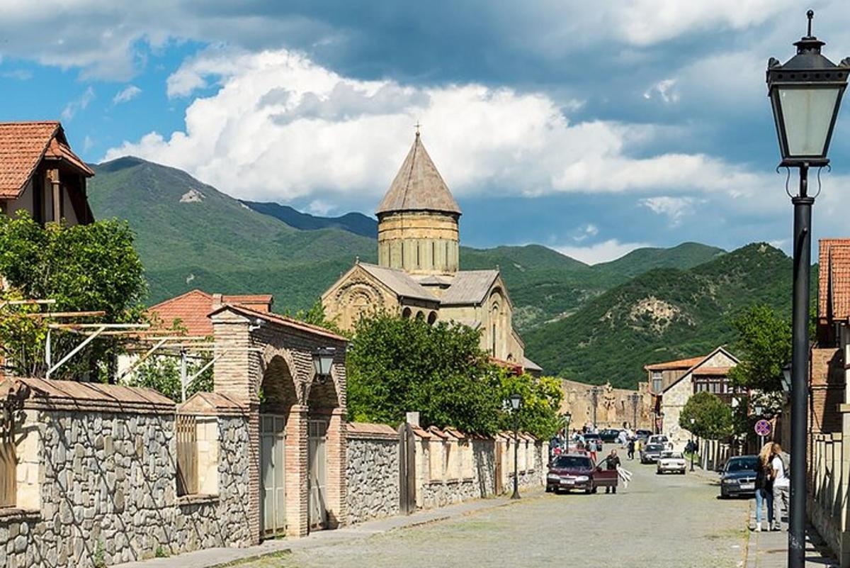una calle de un pueblo con un edificio y una iglesia