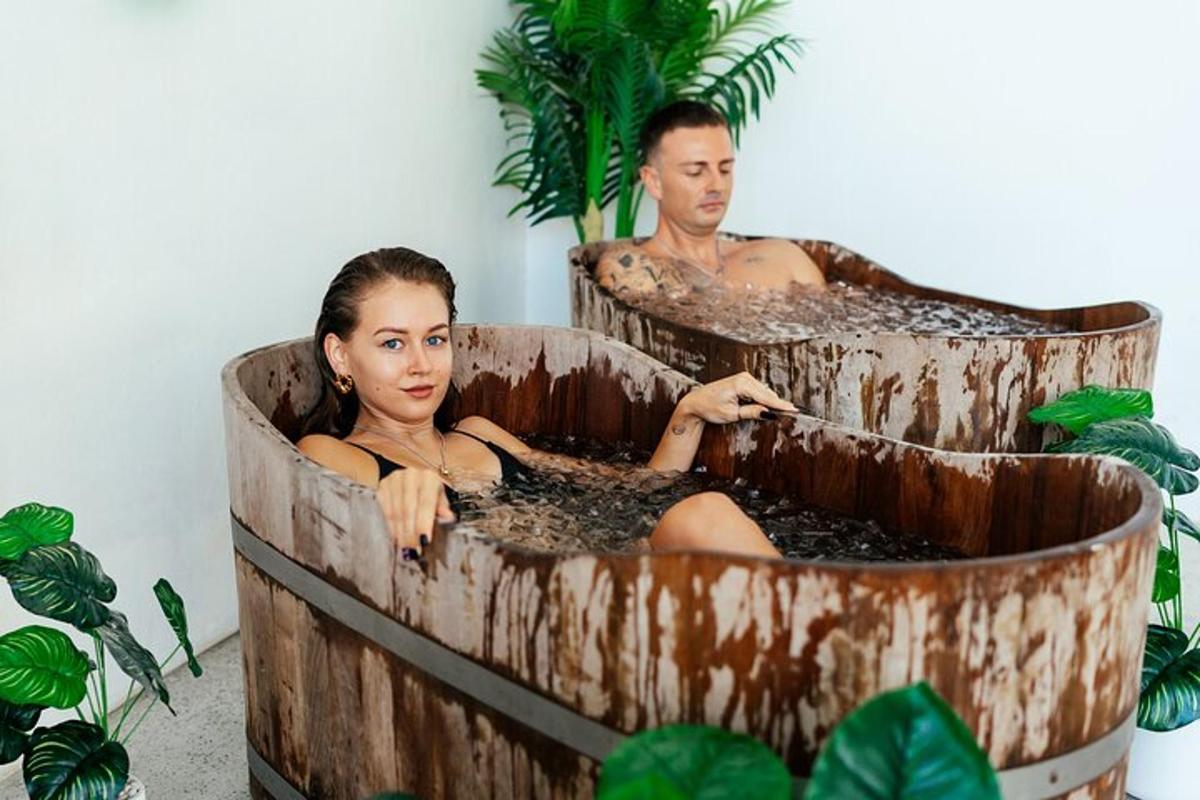 un uomo e una donna seduti in una tinozza di legno
