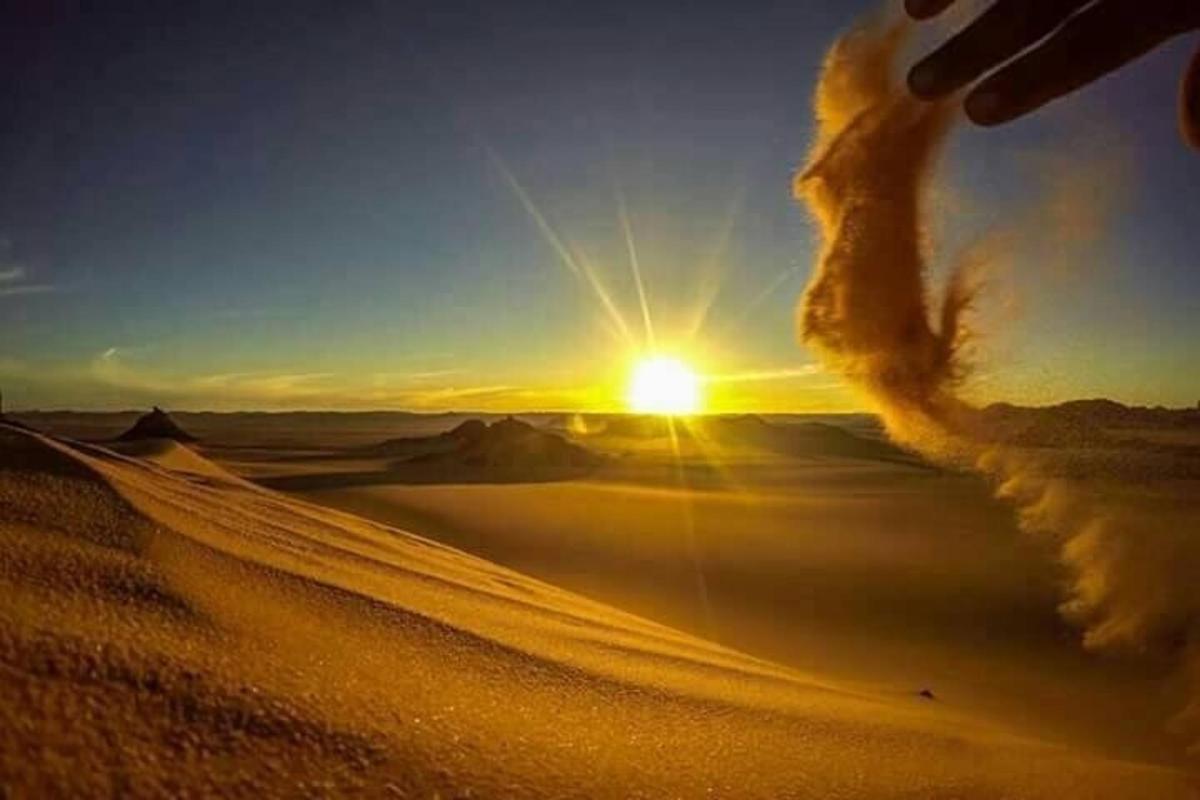 um pôr do sol no deserto com o sol no céu