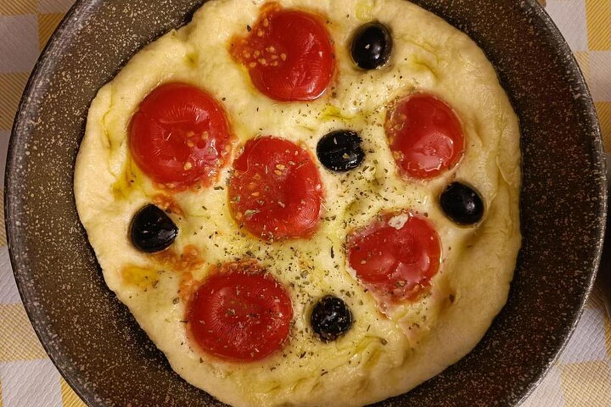 o pizza cu pepperoni și măsline la tigaie