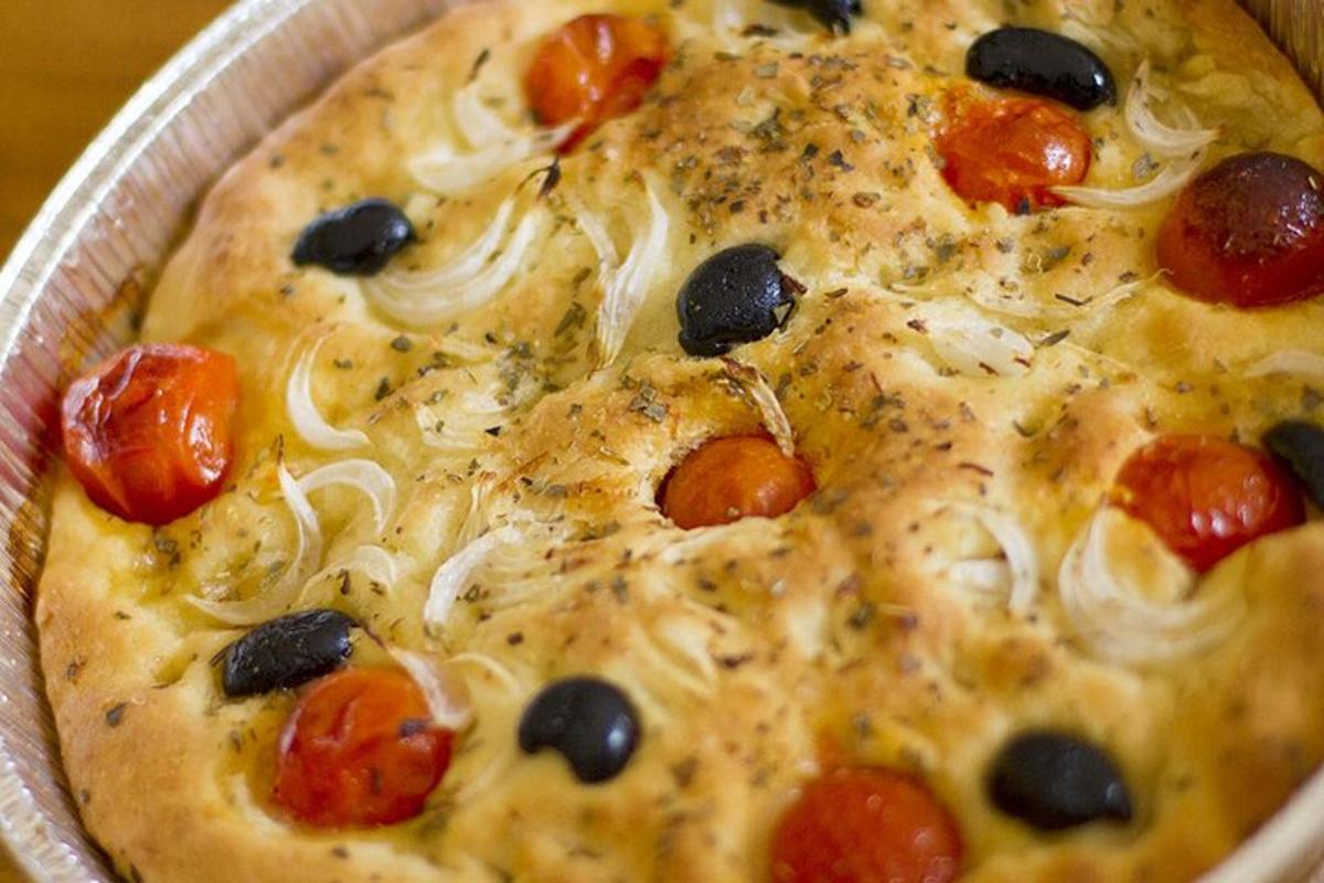 pizza dengan tomato dan buah zaitun dalam kuali