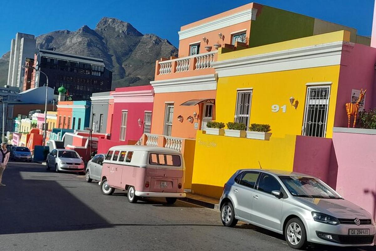 uma rua com carros estacionados em frente a prédios coloridos