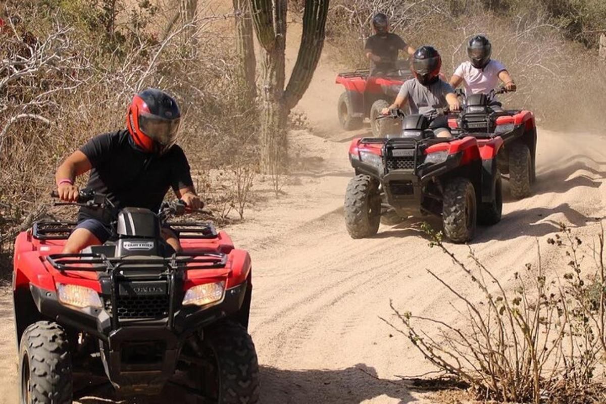 un gruppo di persone che guidano quad su una strada sterrata