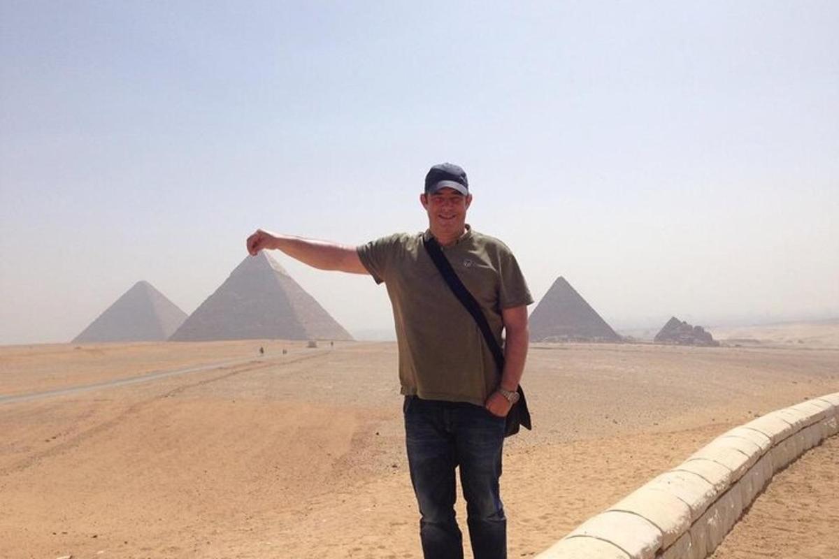 a man is standing in front of the pyramids