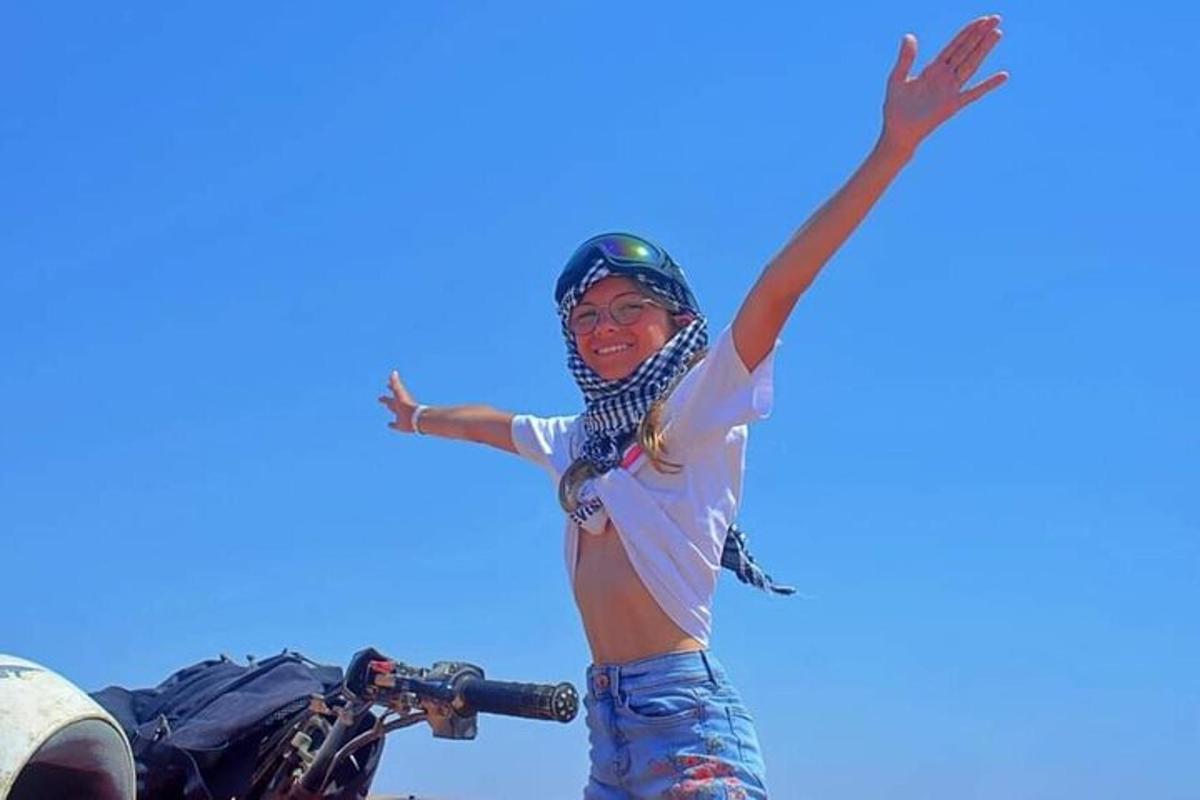 seorang wanita berdiri di sebelah motosikal