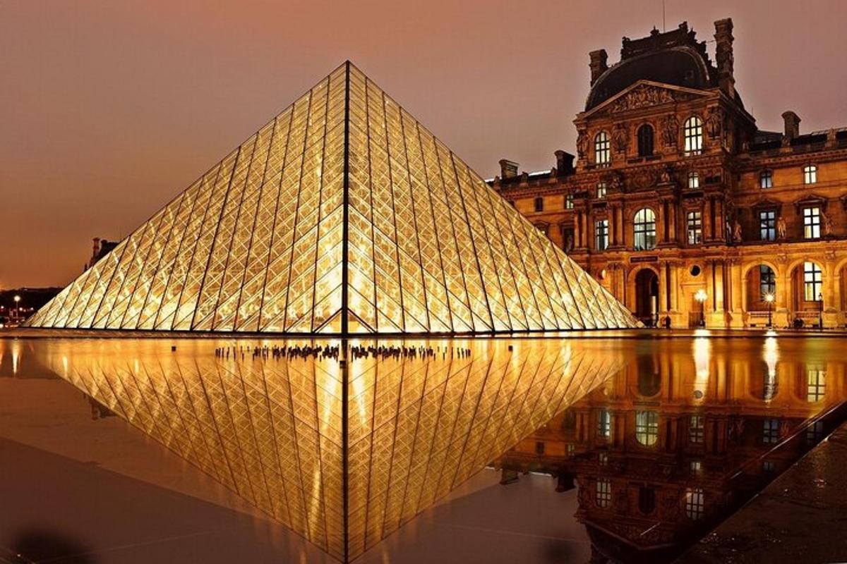 a pyramid is lit up in front of a building