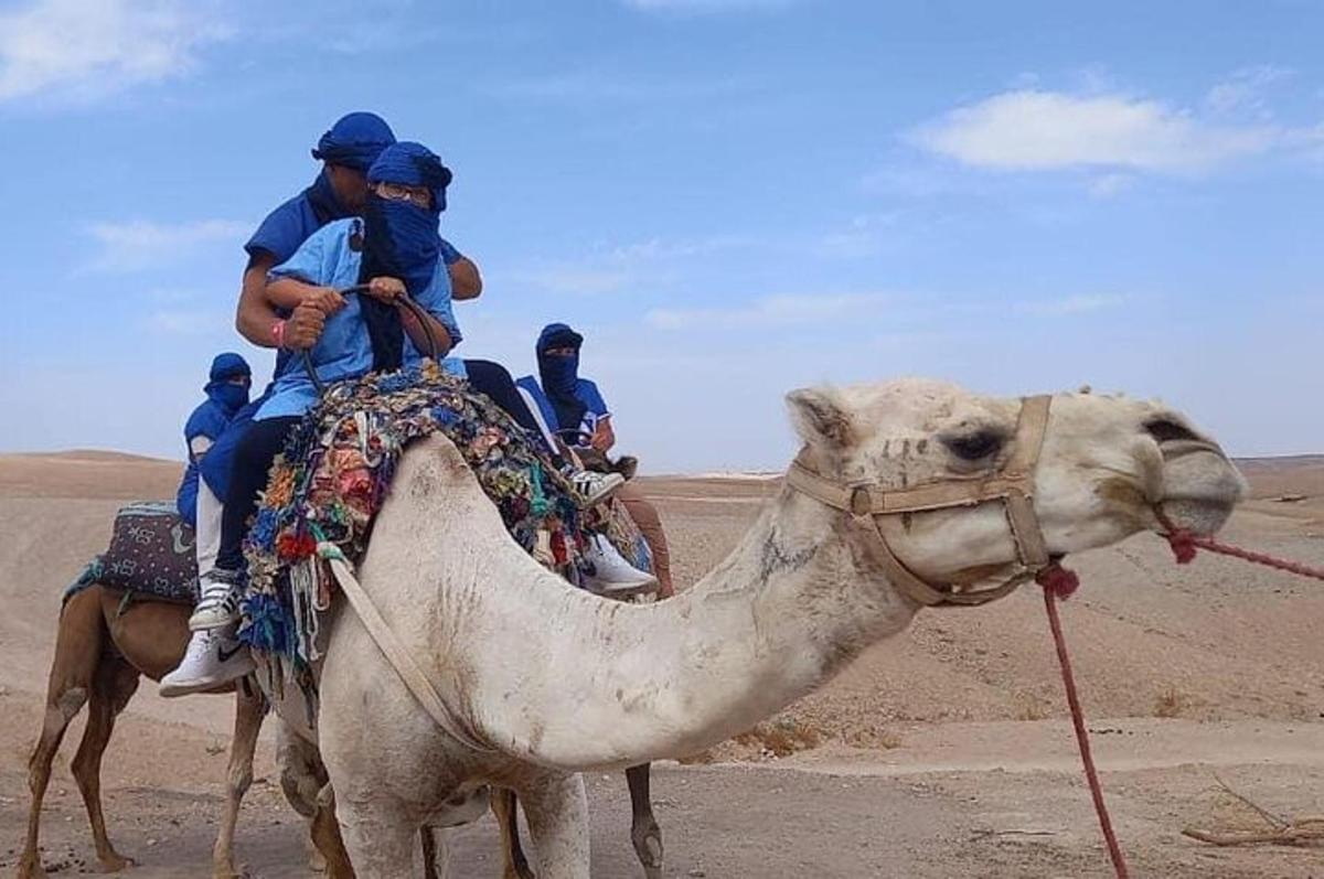 skupina lidí jedoucích na hřbetě velblouda