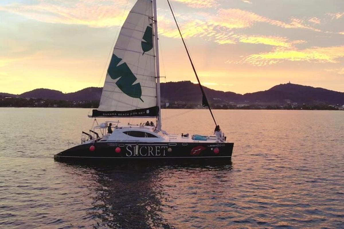 una piccola barca a vela in acqua al tramonto