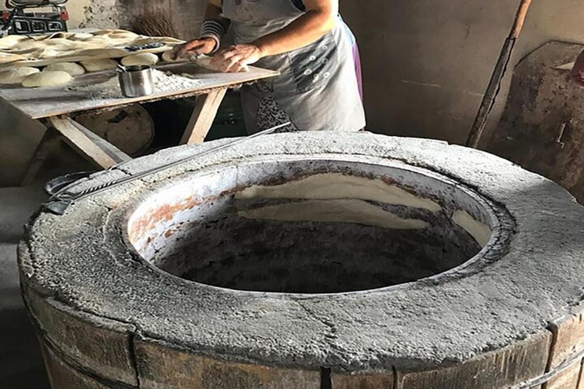 a man is making bread in a large tire