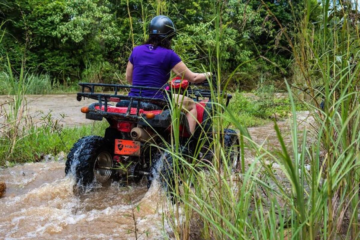 una persona che guida un quad in acqua