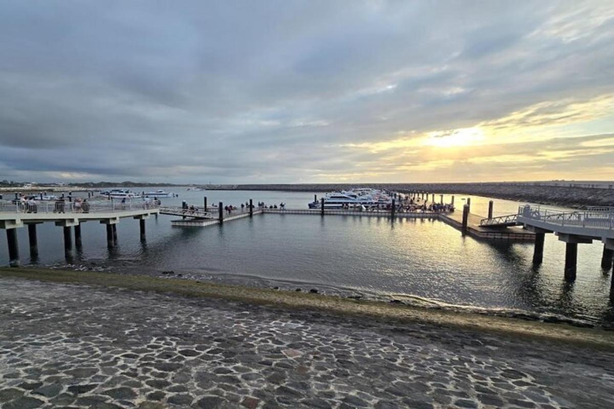 a beach with a pier and boats in the water