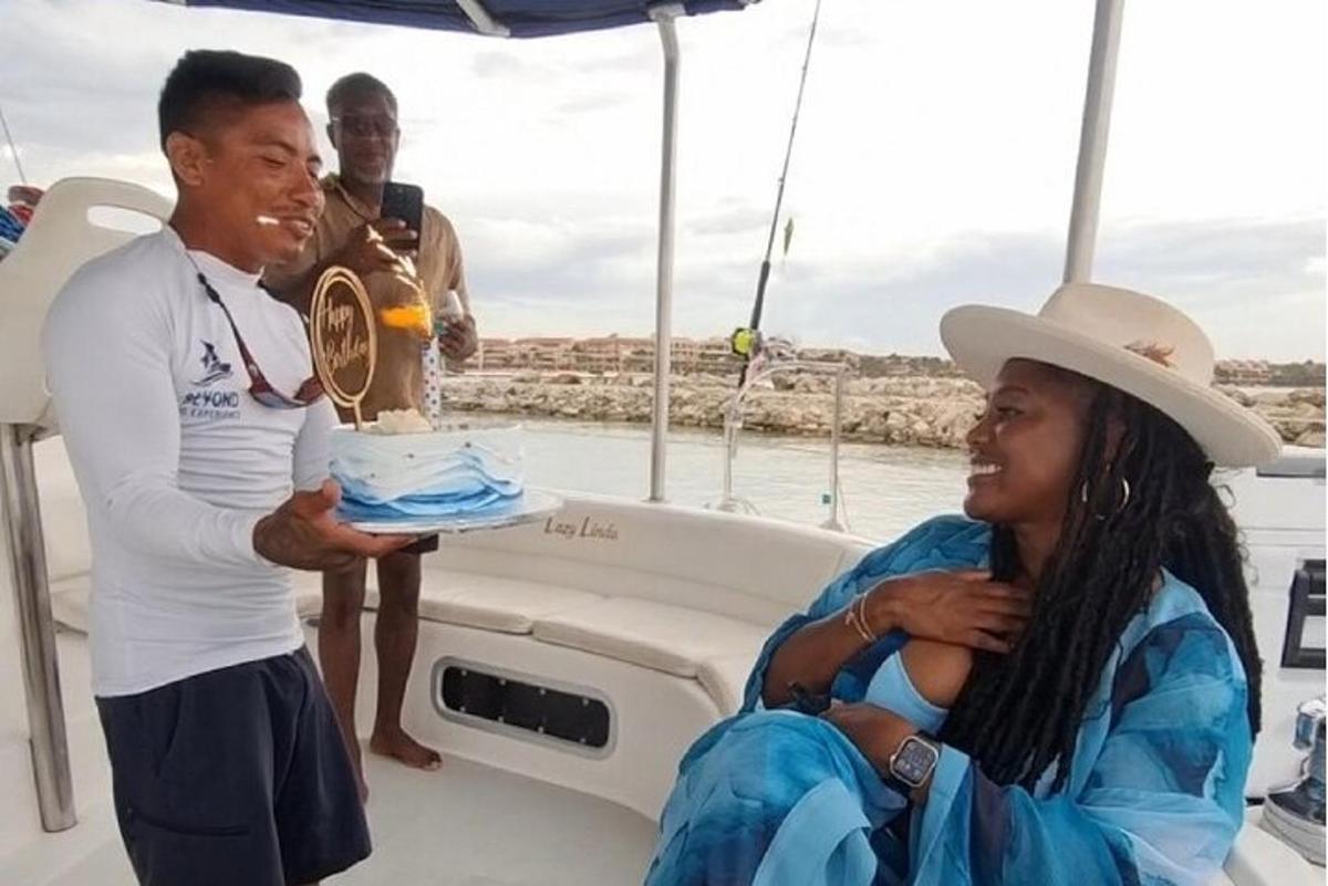 a man holding a woman holding a cake on a boat