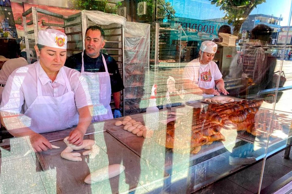 skupina mužů stojících za pultem s jídlem