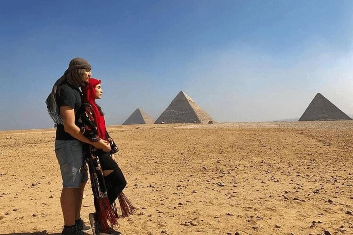 muž a žena stojící před pyramidami