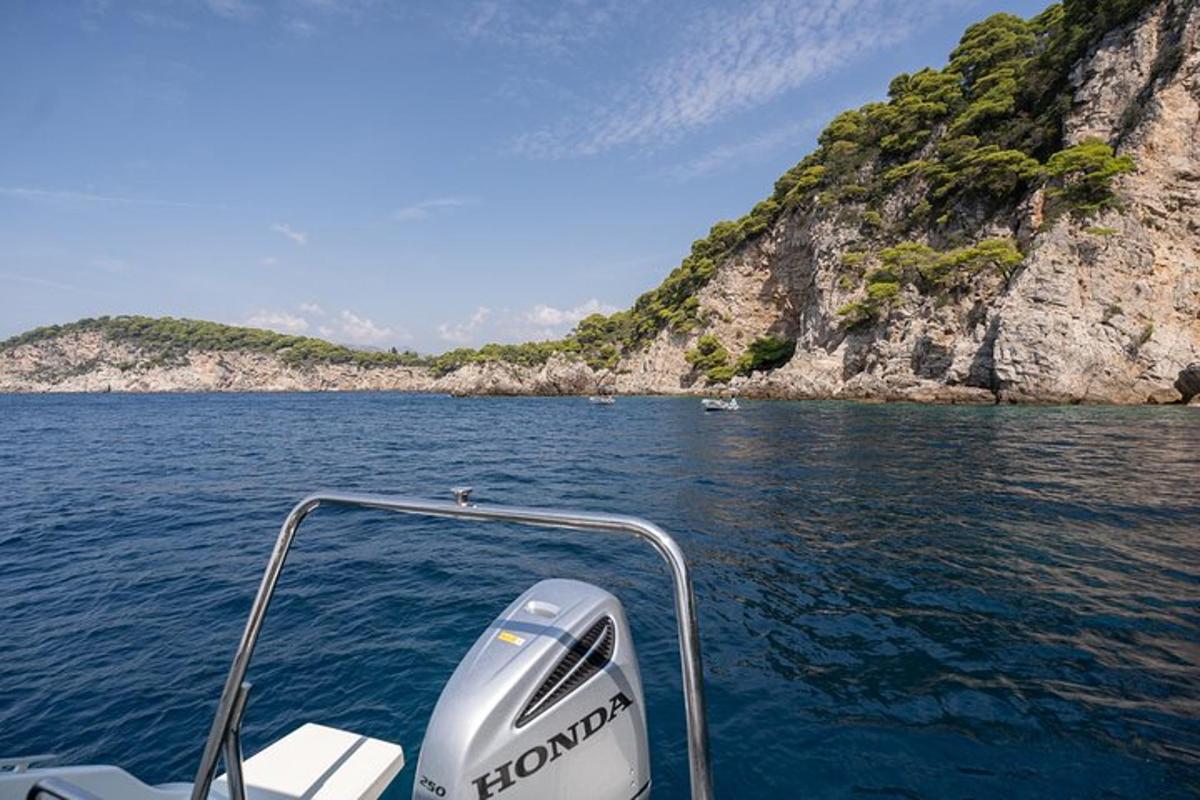 μια βάρκα στο νερό δίπλα σε ένα βραχώδες νησί