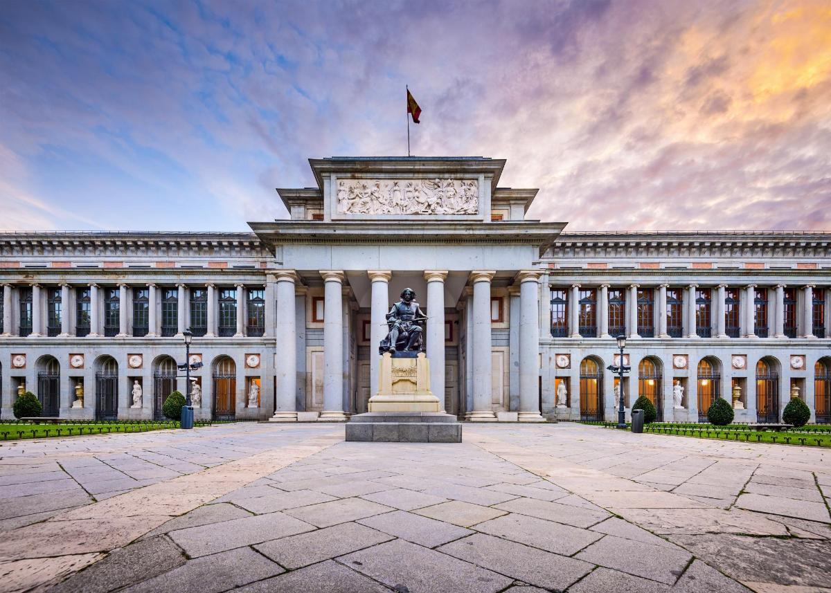 Un gran edificio con una estatua delante.