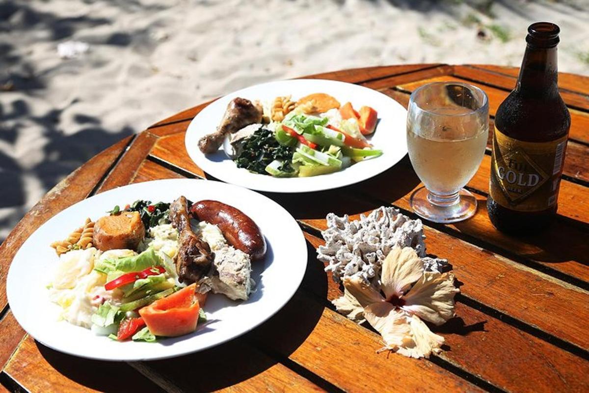 two plates of food on a table with a bottle of beer