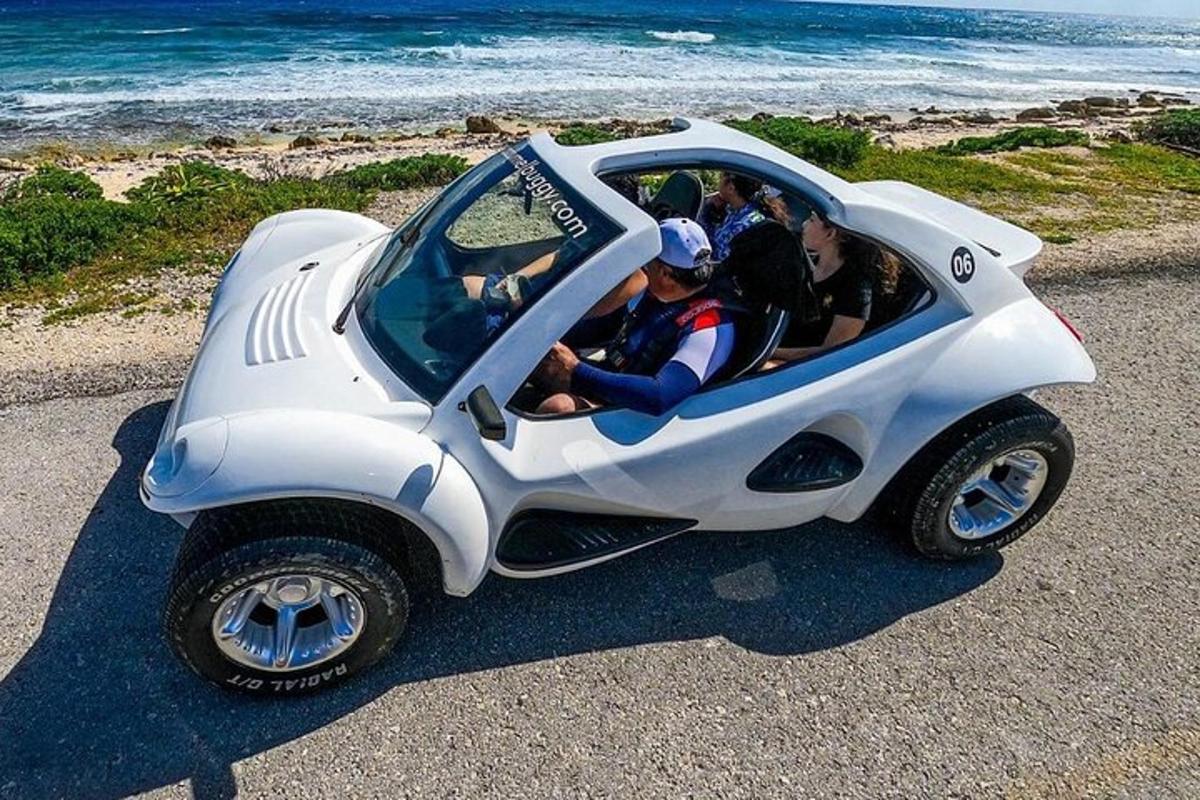 skupina ljudi v avtomobilčku na plaži