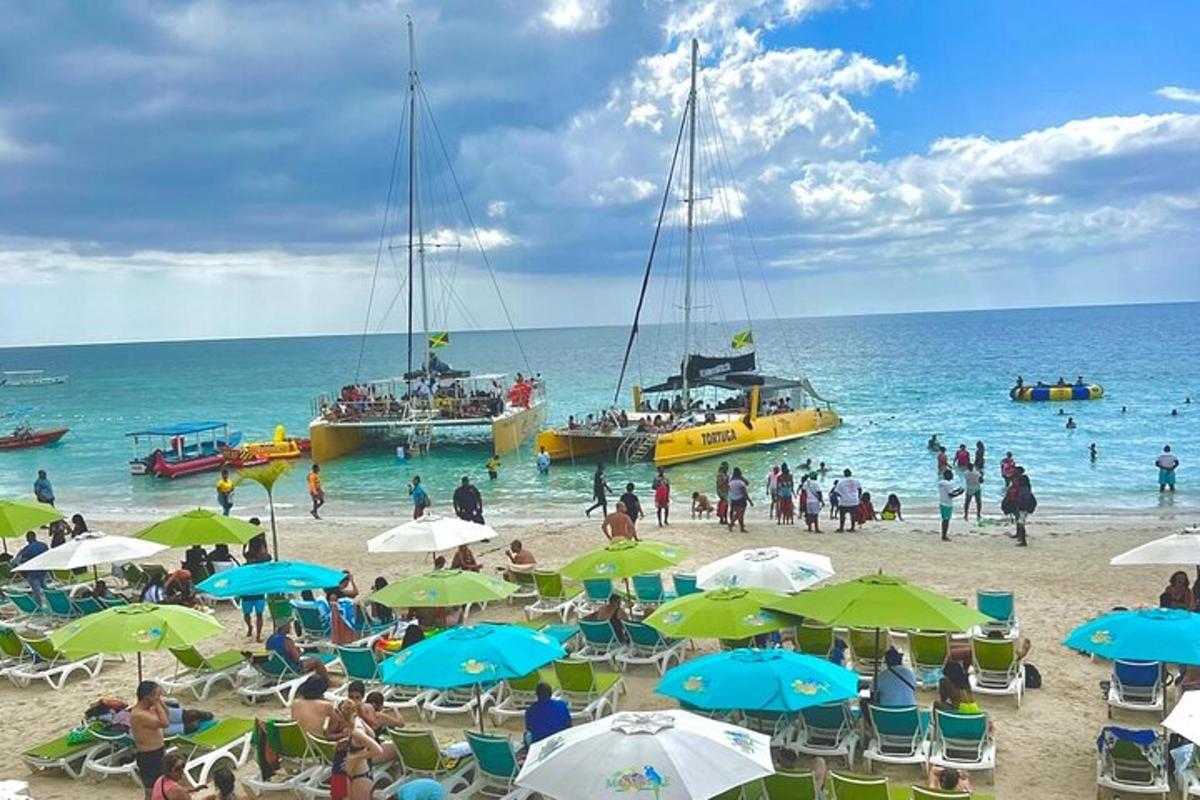 un gruppo di persone su una spiaggia con barche in acqua