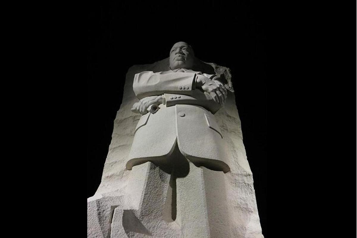een standbeeld van een man die bovenop een toren zit