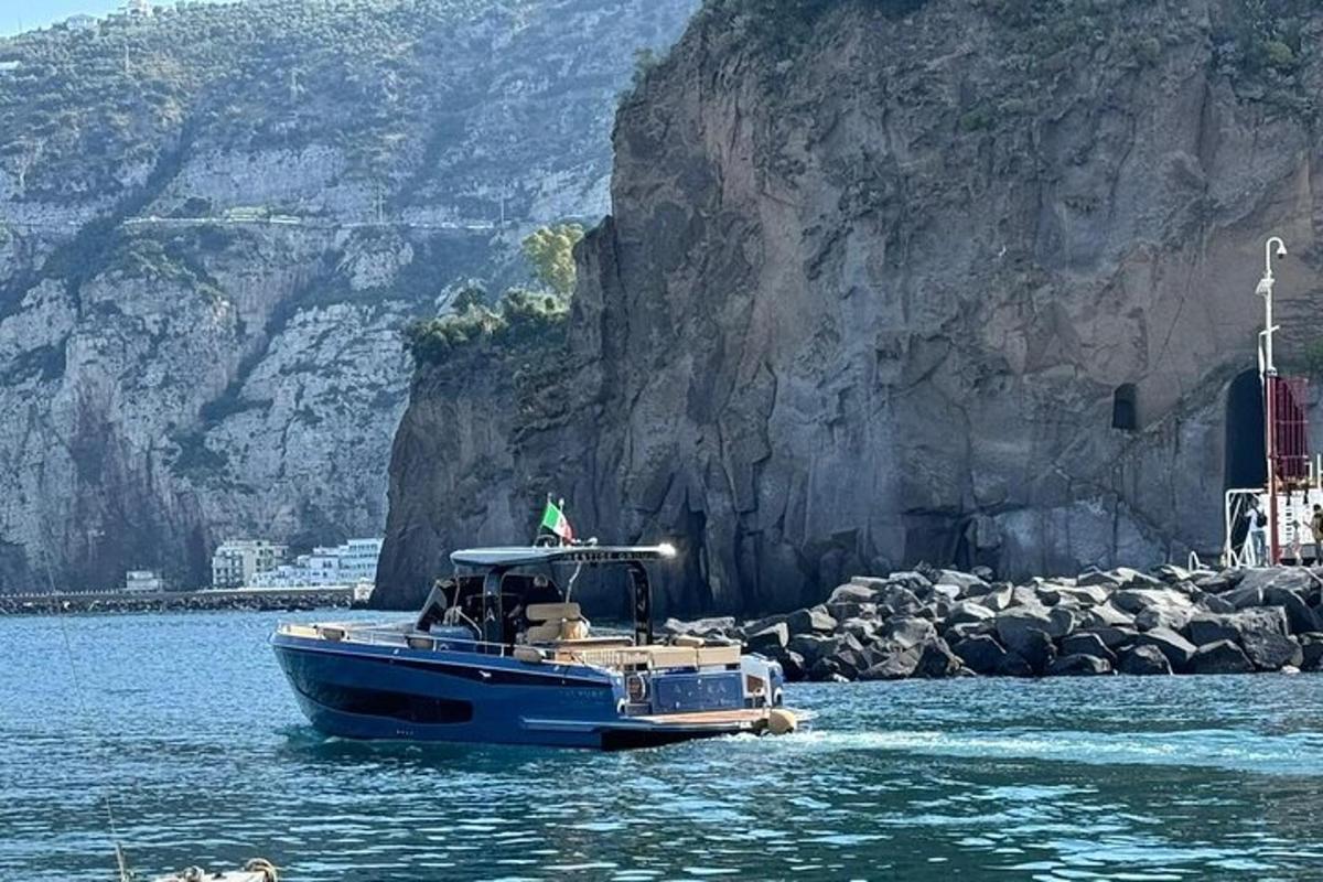 isang asul na bangka sa tubig sa tabi ng isang bundok