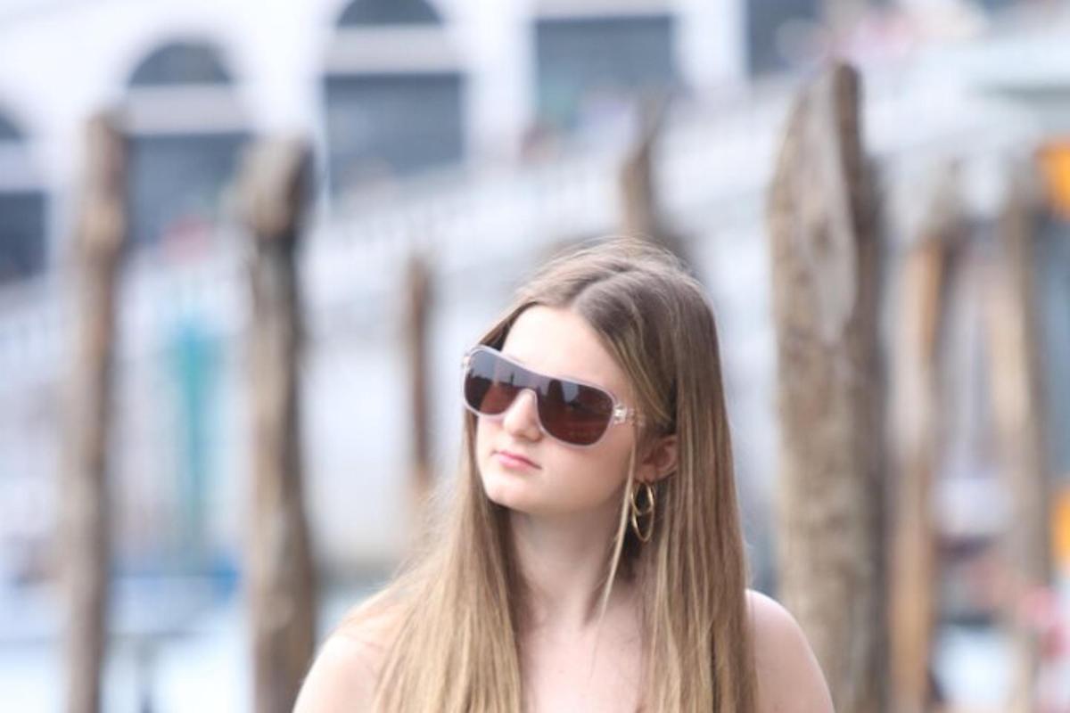 una giovane donna che indossa occhiali da sole e ascolta musica