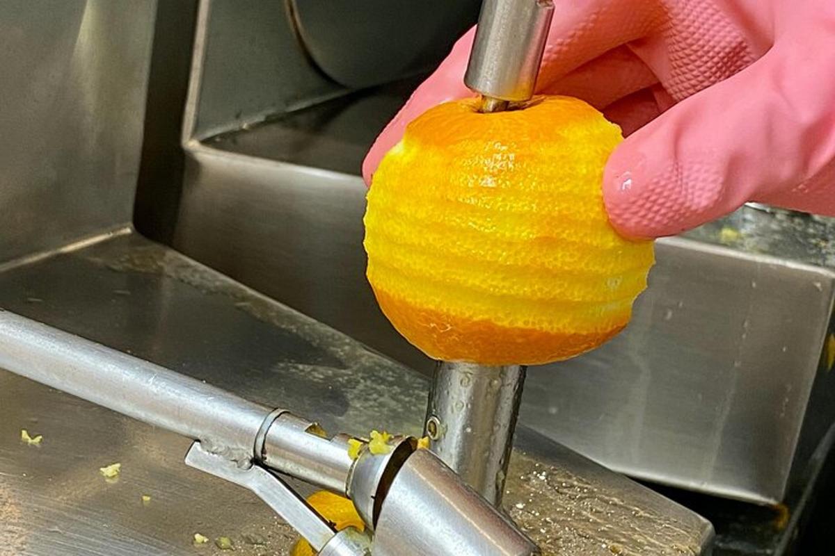 uma pessoa está cortando uma laranja com uma faca