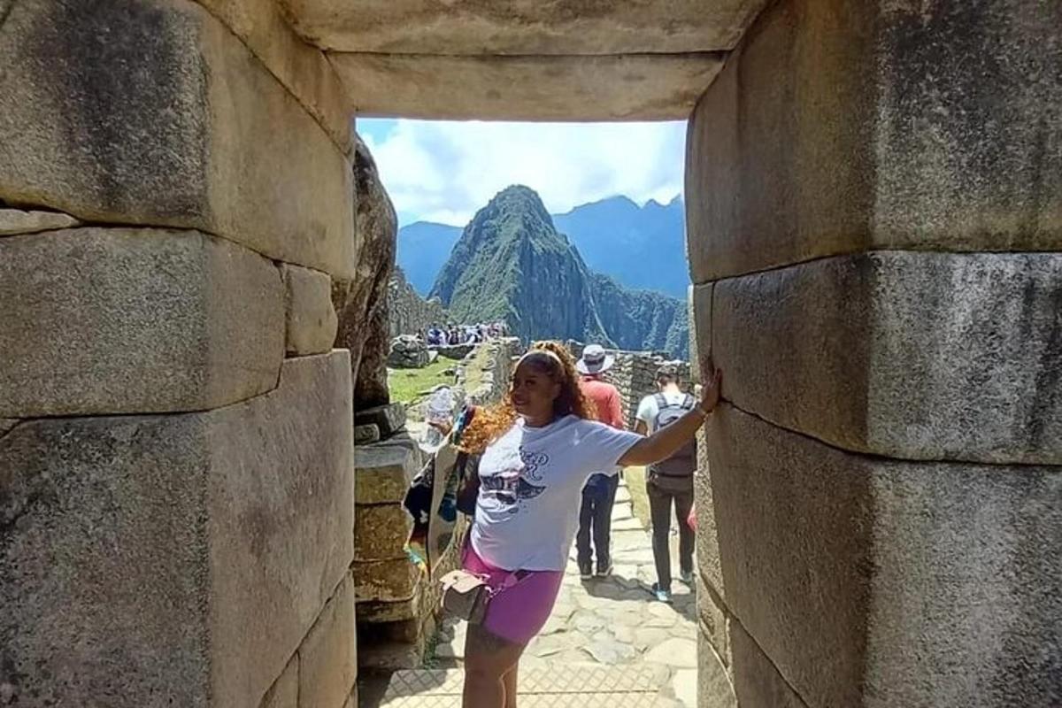 seorang wanita berdiri di ambang pintu dinding batu