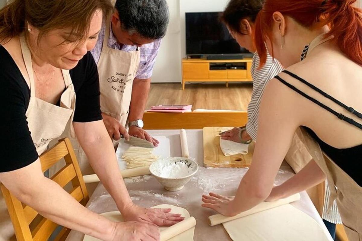Un grupo de personas de pie alrededor de una mesa con masa.