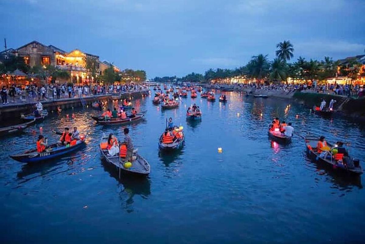 un grup de persones en barques en un riu a la nit