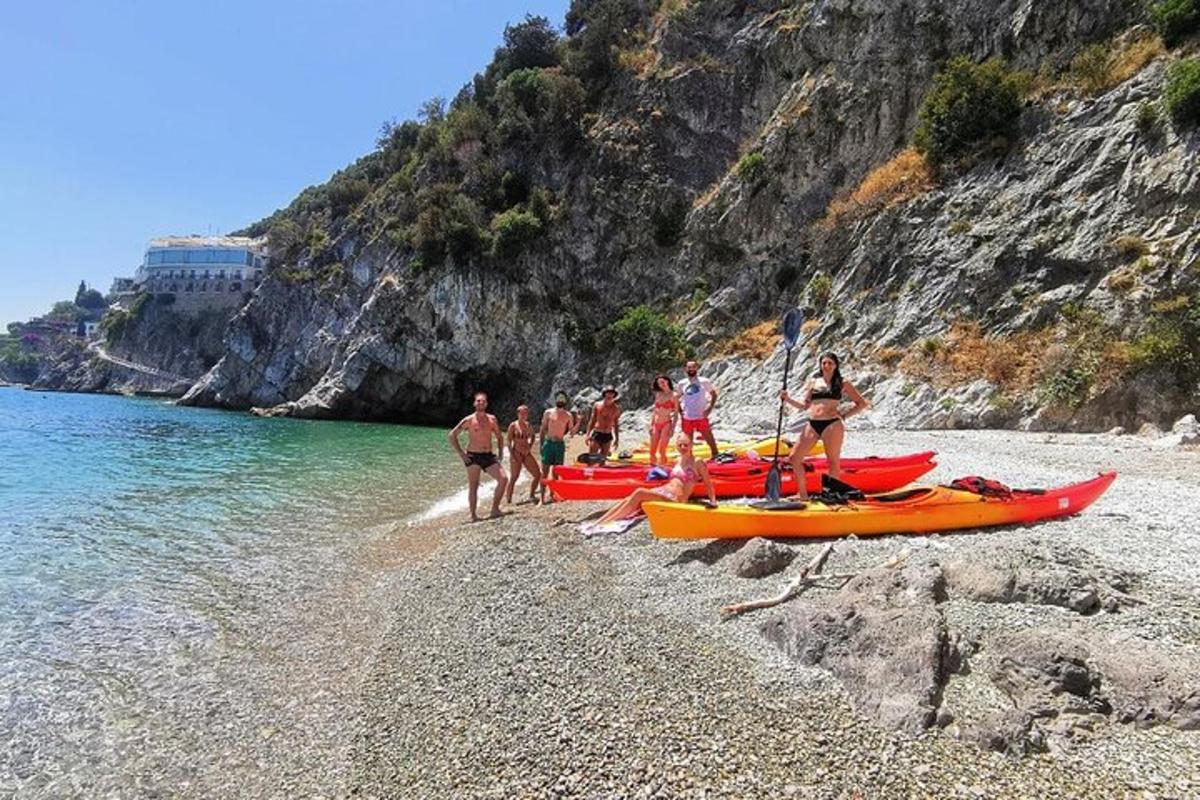 a group of people standing on a beach with canoes