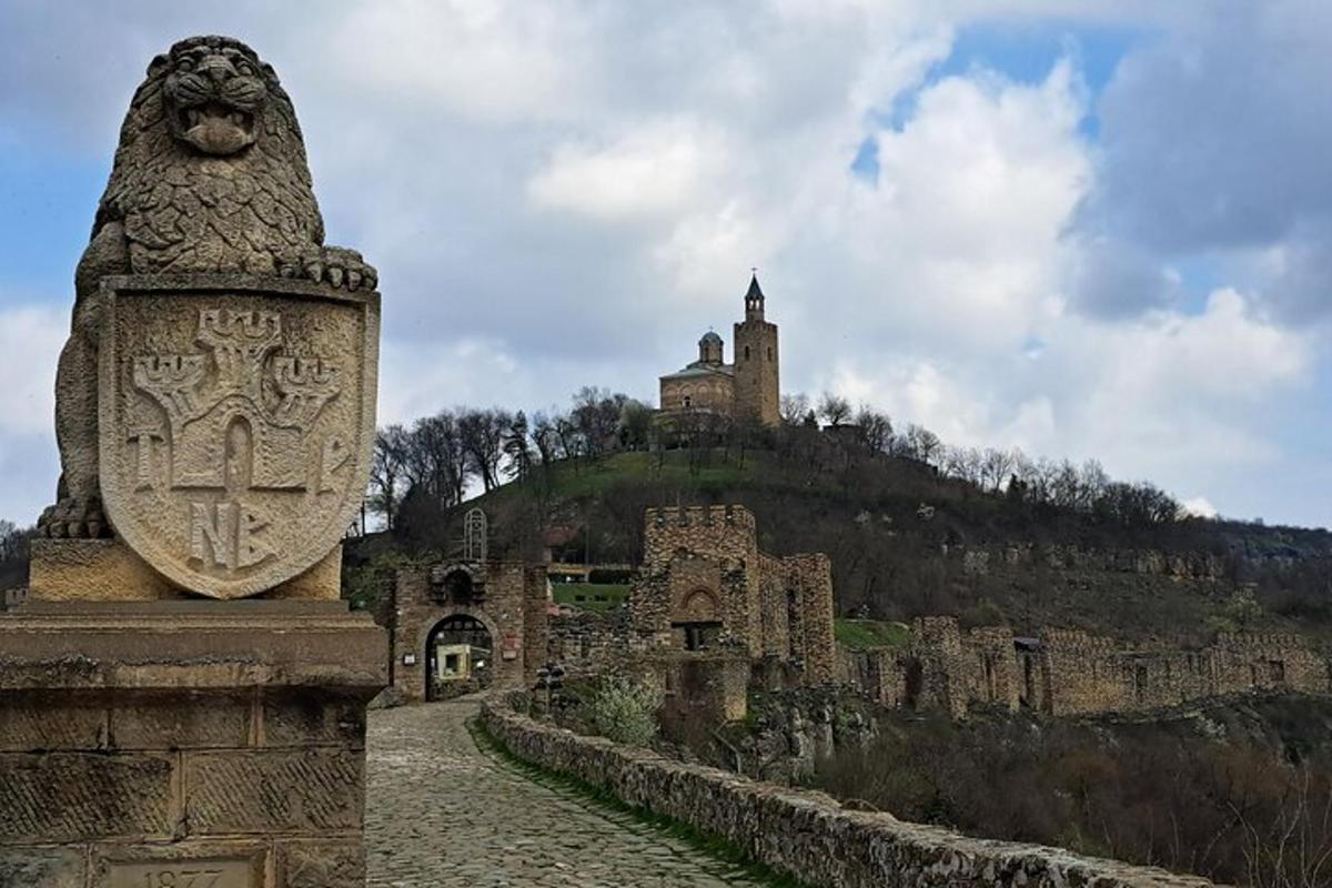 una statua di pietra di fronte a un castello su una collina