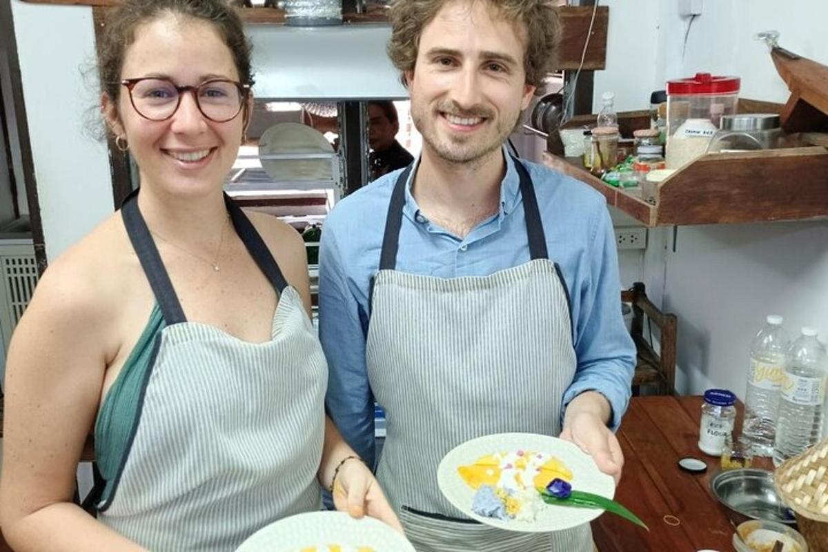 vīrietis un sieviete priekšautiem mugurā tur ēdienu šķīvi