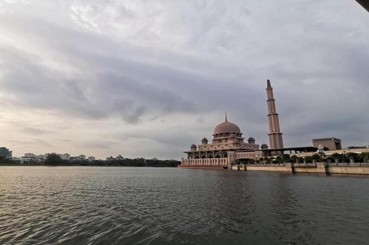 a mosque sitting on the side of a body of water