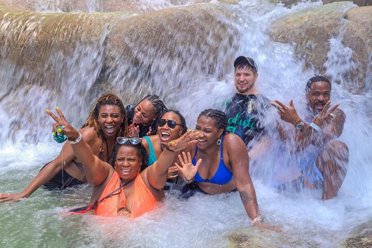 a group of people posing in front of a waterfall