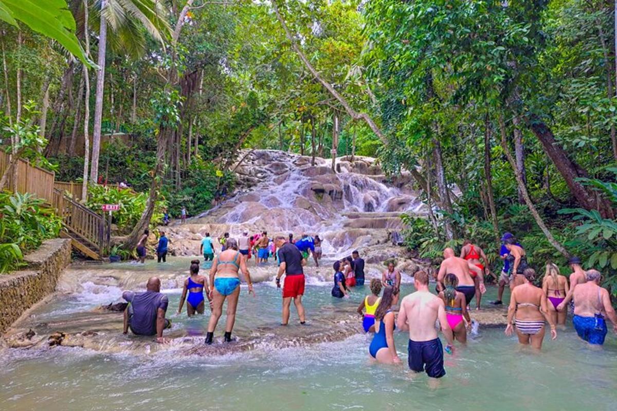 a group of people in the water at a waterfall