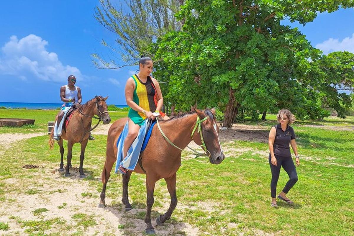 two people riding horses in a field with a woman