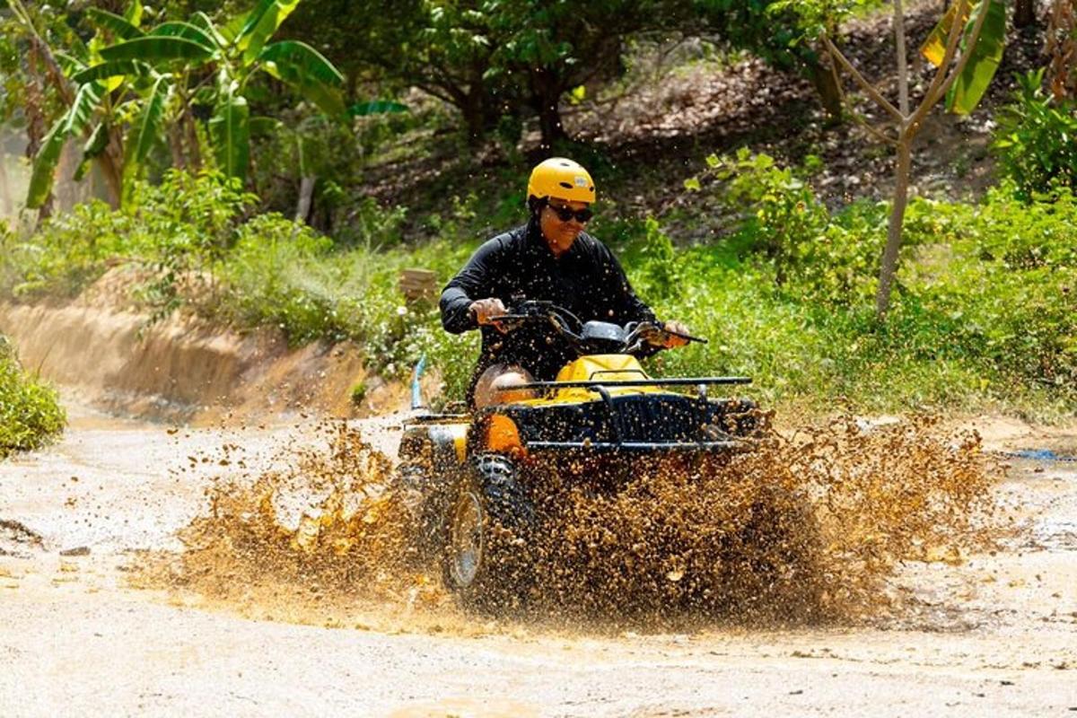 un uomo che guida un quad nel fango