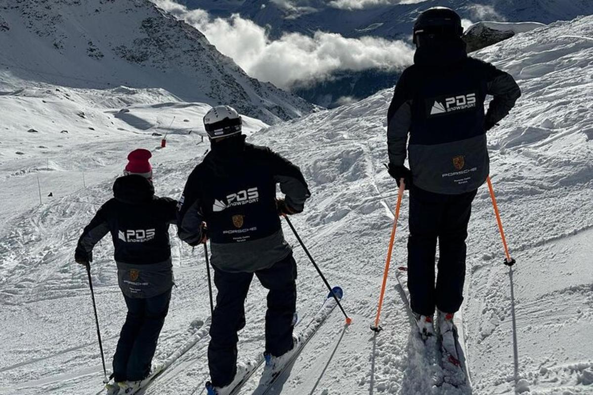 a group of three people standing on a ski slope