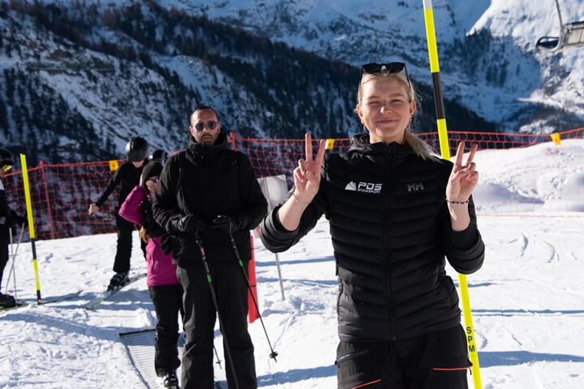 a woman giving the peace sign while standing in the snow