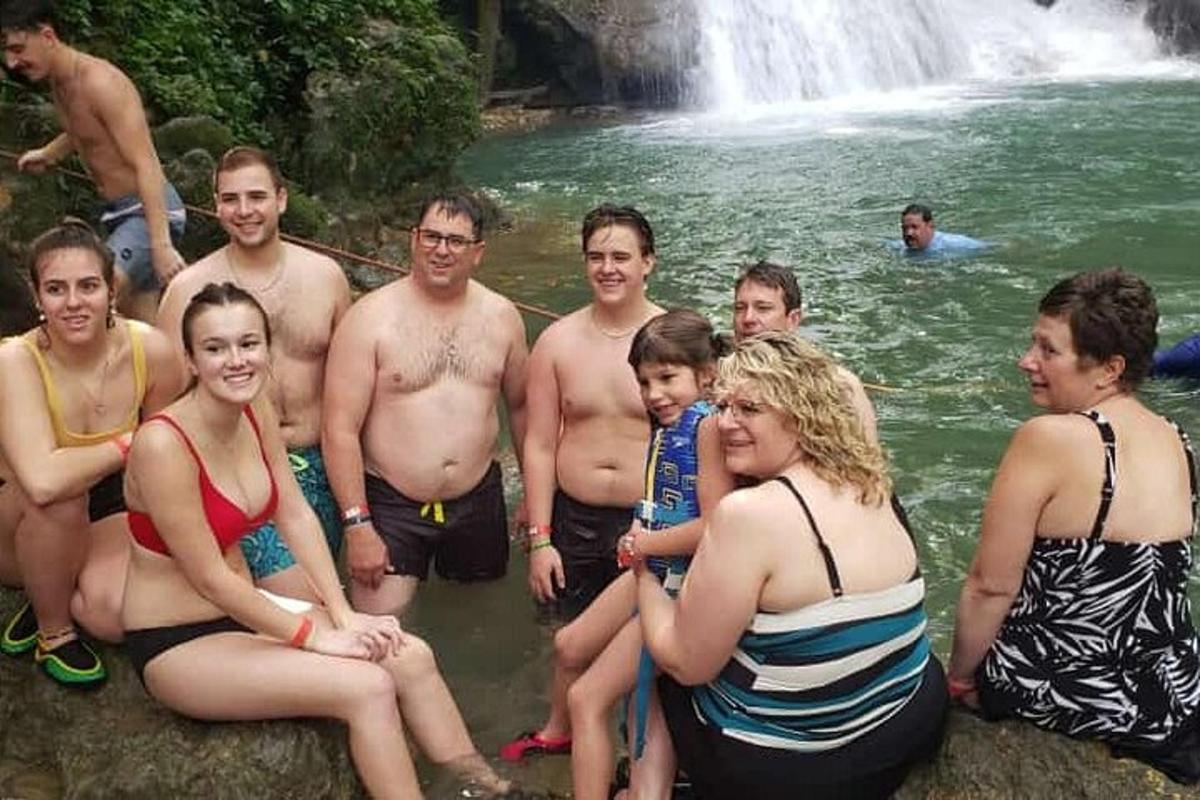 un gruppo di persone in acqua vicino a una cascata
