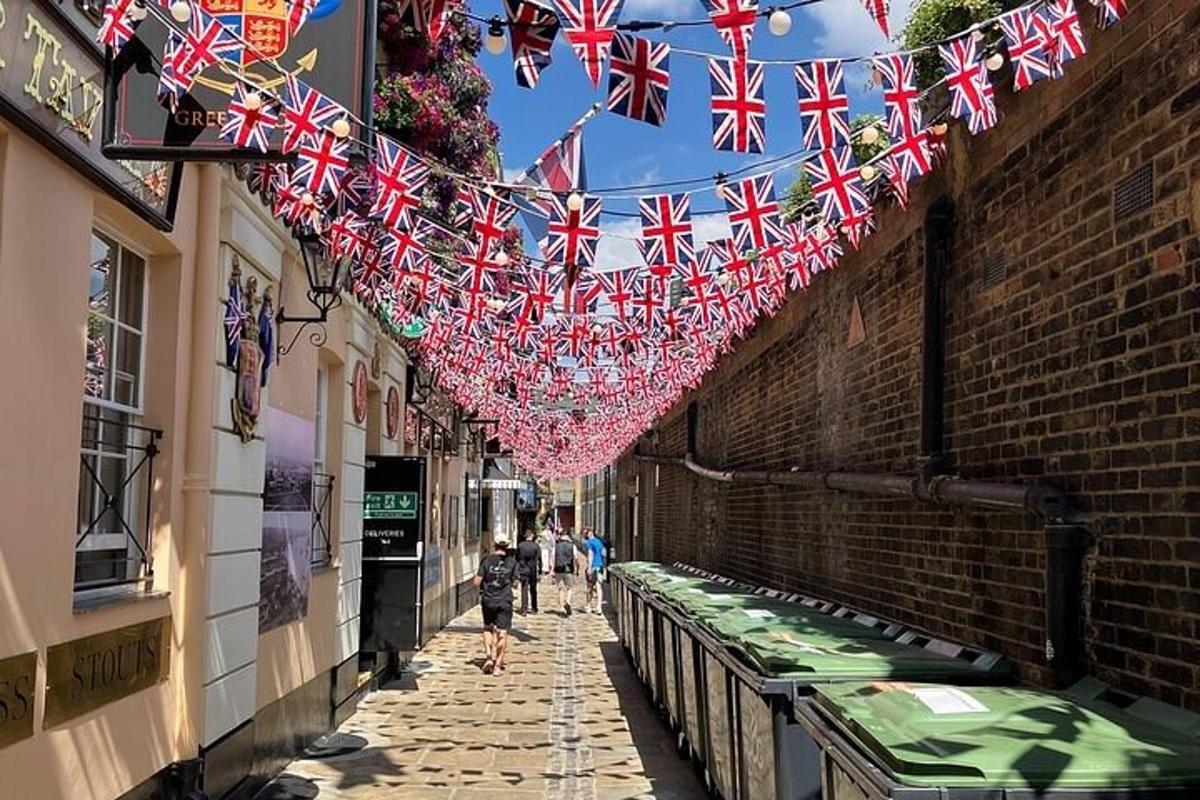 a narrow alley with british flags hanging from buildings