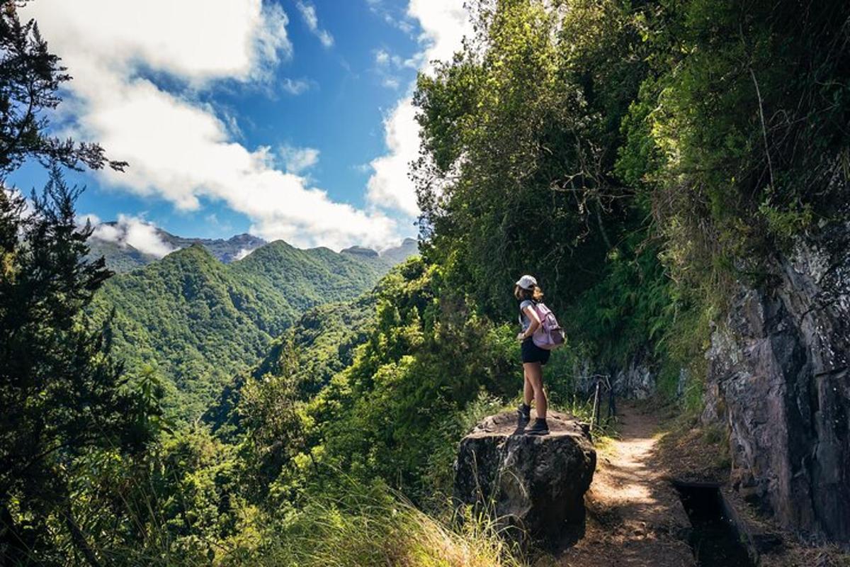 seorang wanita berdiri di atas batu di laluan gunung