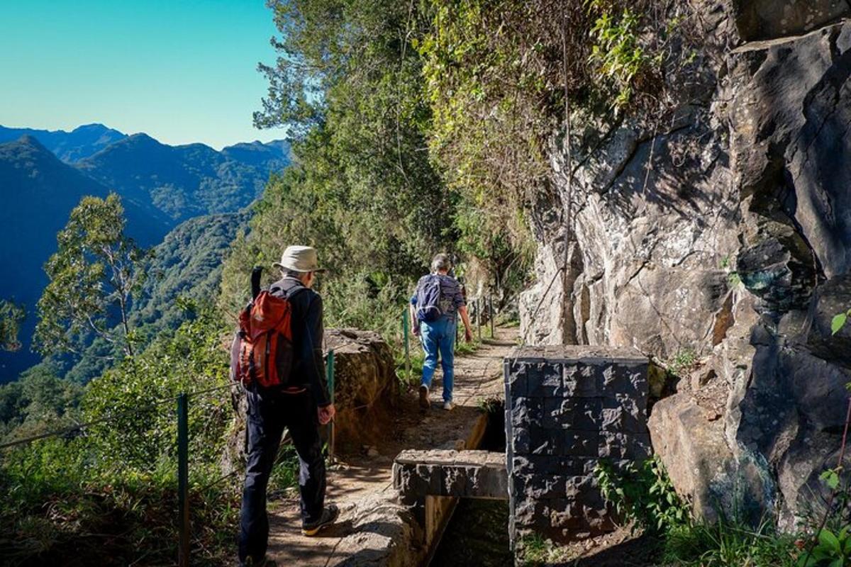 dua orang berjalan di atas denai gunung
